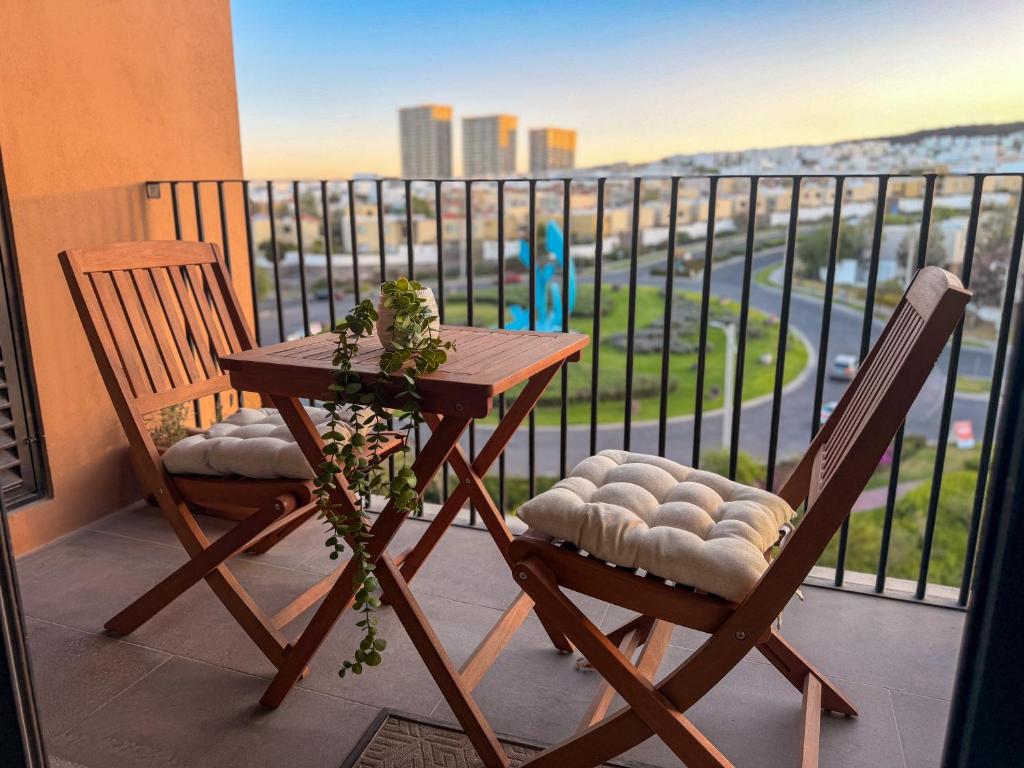 a table and two chairs on a balcony with a view at Loft en Zibata con Vista Alberca y Gym in La Cañada