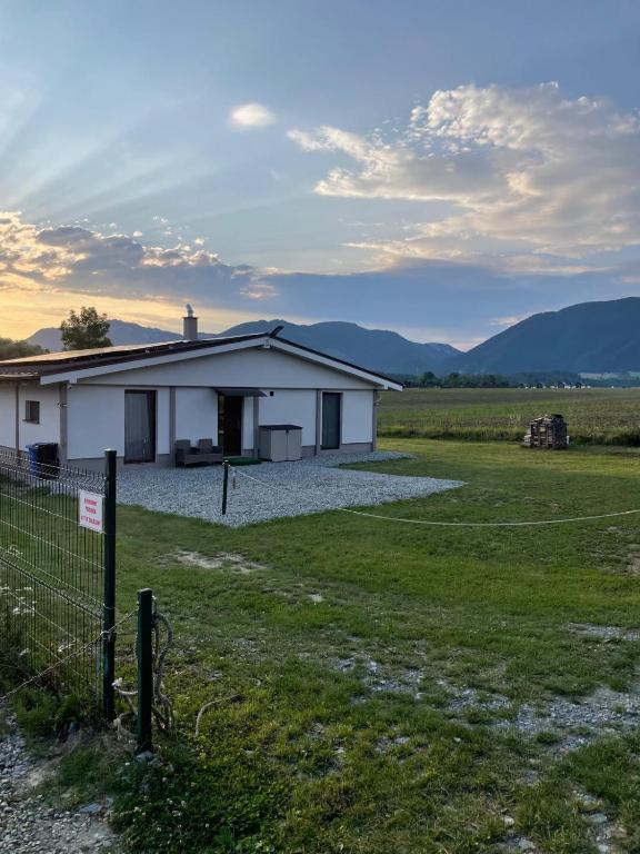 a white house in a field with a fence at Ubytovanie v objatí Liptova in Žiar