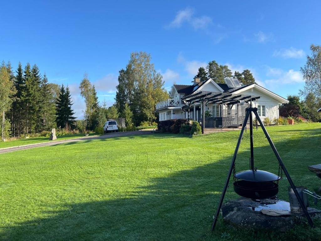 a house with a grill in front of a yard at Solhem Terrassen in Arvika