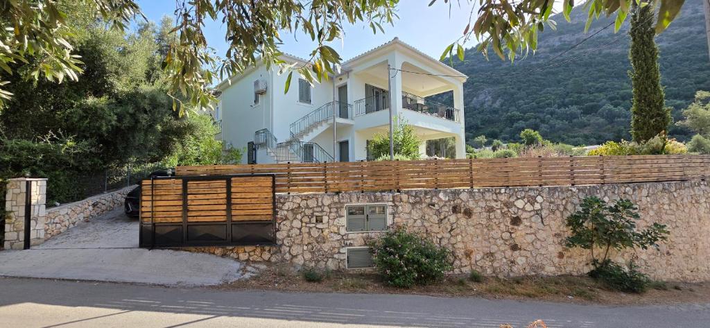 a house on a hill with a stone wall at Sissy Villas 1 in Poros