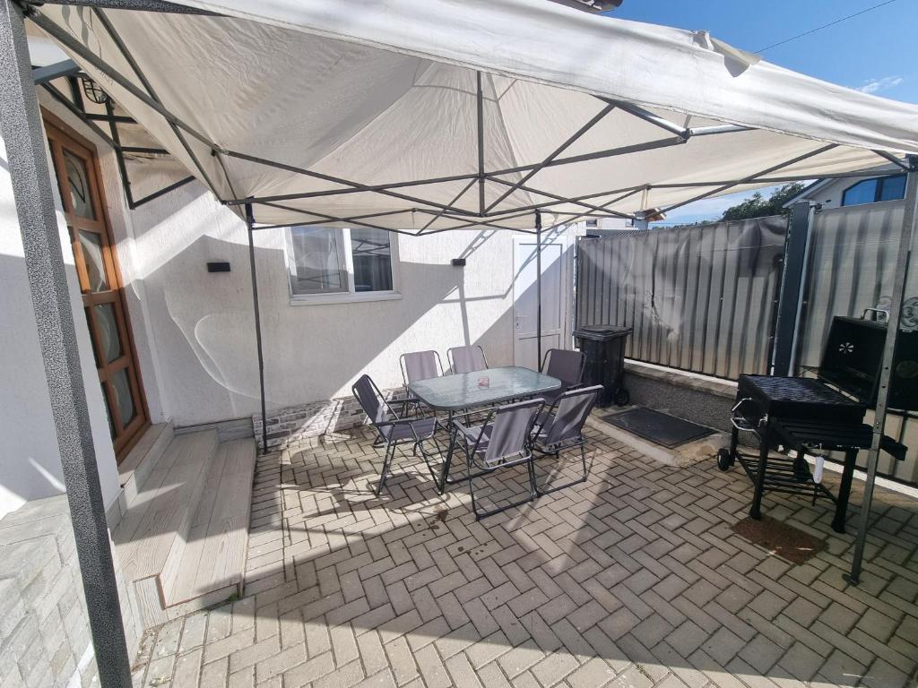a patio with a table and chairs under a tent at Casa Lumi in Petrila