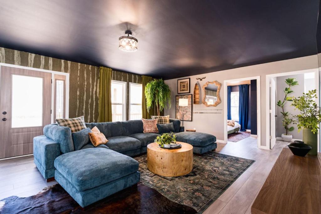 a living room with a blue couch and a table at 5BR Hocking Hills Cabin, Arcade, Forest Views in South Bloomingville