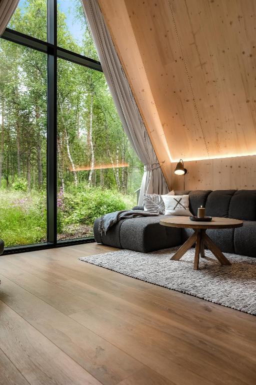 a bedroom with a bed and a table and windows at Holmen Husky Lodge in Alta