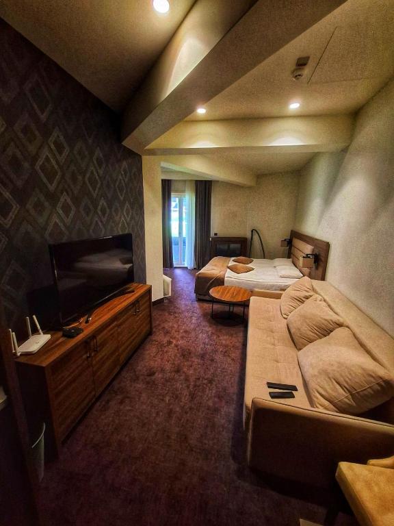 a hotel room with two beds and a flat screen tv at LUNAS Apartmani in Kopaonik