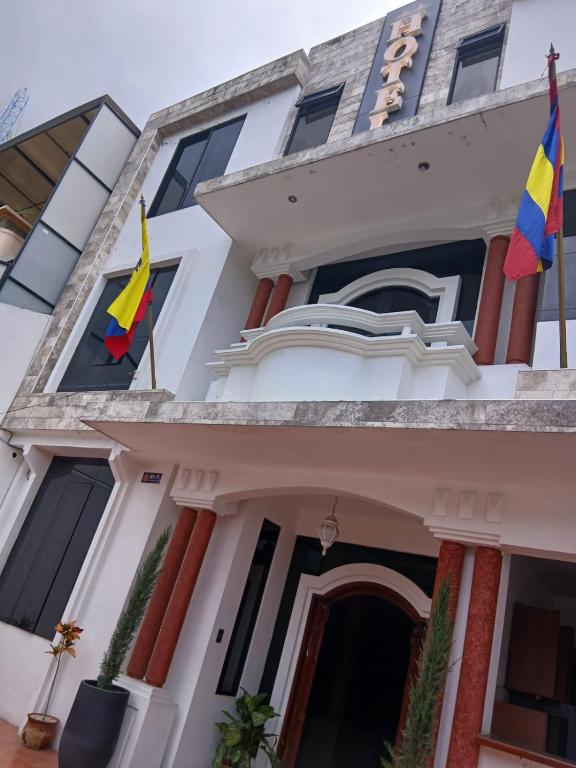 ein Gebäude mit Flaggen davor in der Unterkunft Hotel Jomaley in Loja