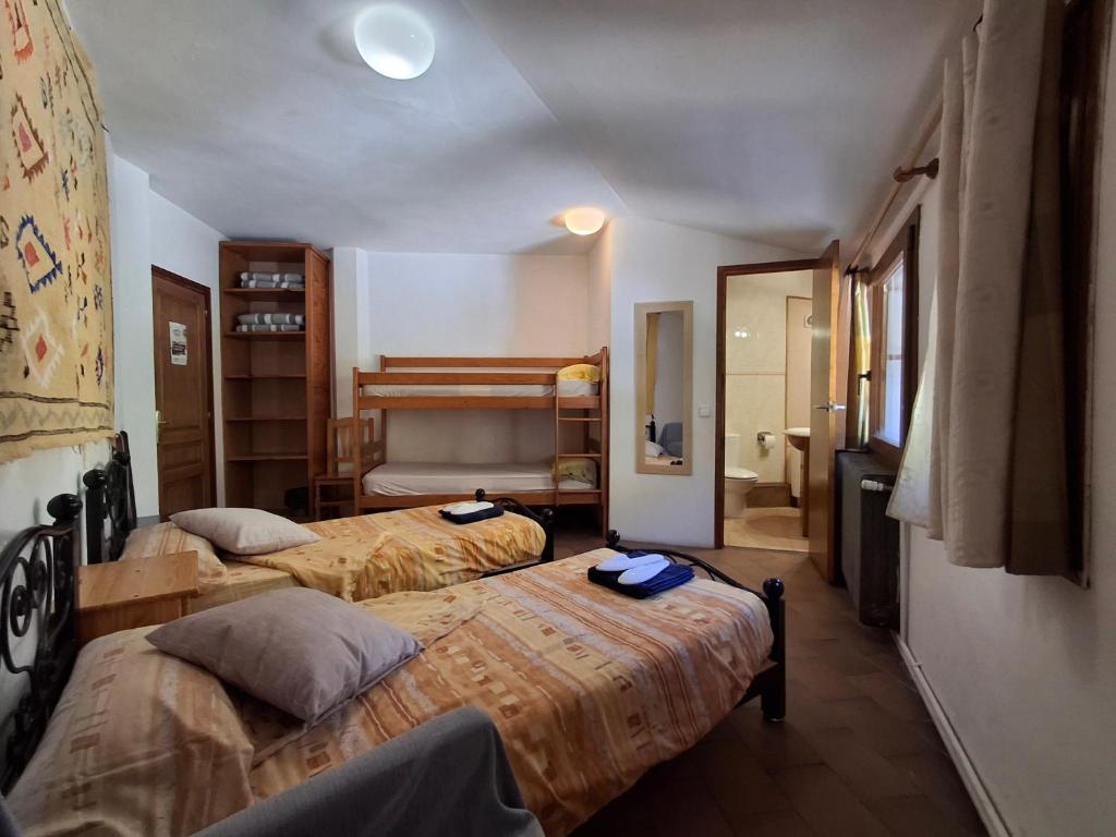 a hotel room with two beds and a bathroom at Setcases-Vallter hostal Mitja Pensió 3 in Setcases
