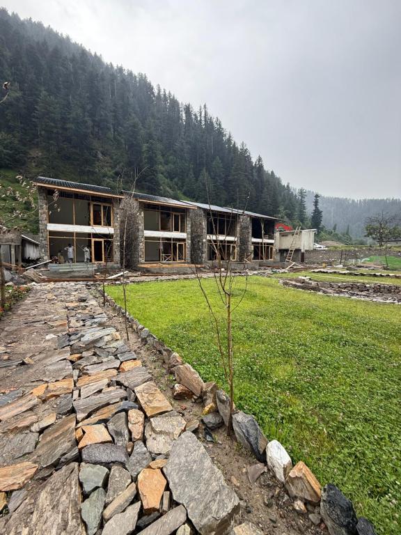 a stone path leading to a building in a field at Lavender Resort Naran in Naran