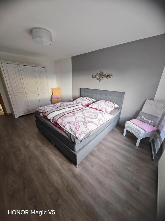 a bedroom with a large bed and a chair at Ferienwohnung Bahnhof Ehr in Halsenbach
