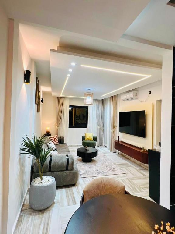 a large living room with a couch and a tv at Mandys Guest House in Yaoundé