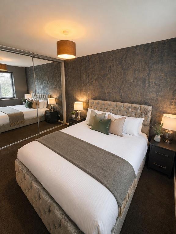 a hotel room with a large bed and mirrors at Stylish 2-Bed Flat, Minutes to Southport Centre in Southport