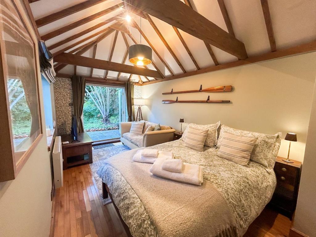 a bedroom with a bed with two towels on it at The Willow Nest in Hambleden