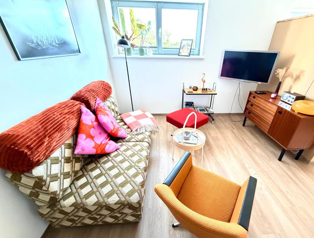 a living room with a couch and a tv at Joe's Home Naumburg -modern,vintage Apartment in Naumburg