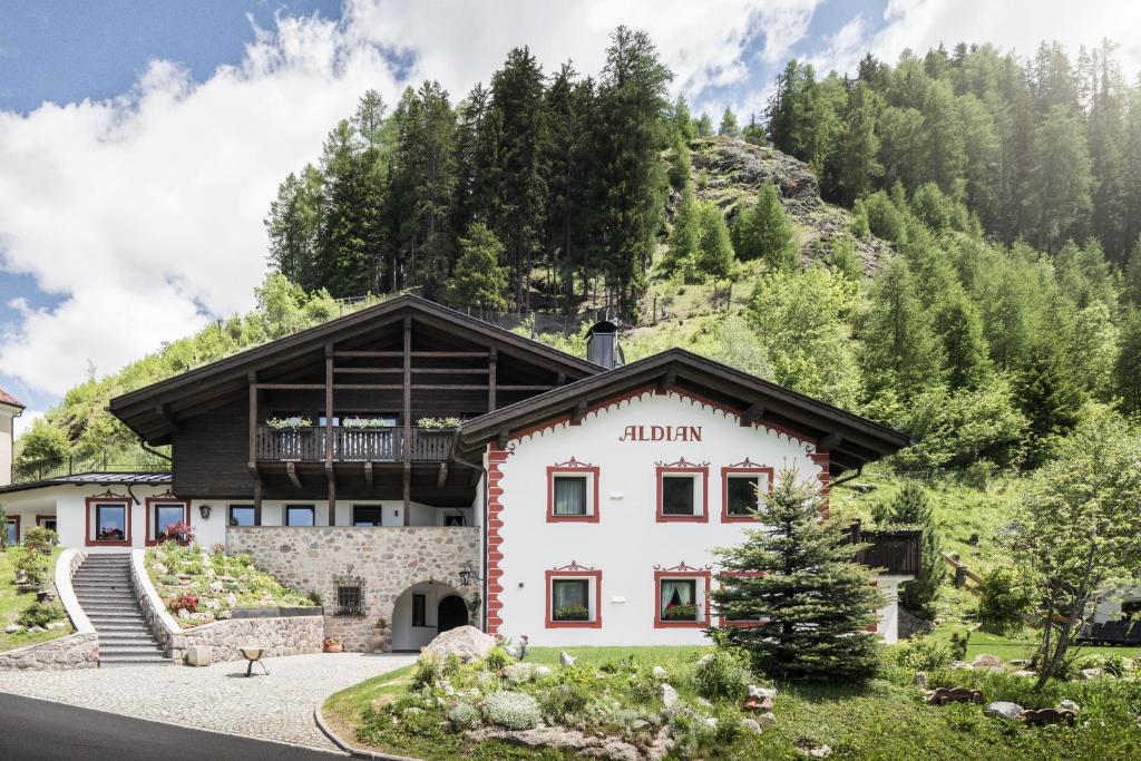 a building in the mountains with trees at Chalet Aldian Dolomites in Selva di Val Gardena