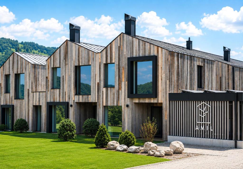a house with wooden cladding on a green lawn at AMIL chalets dolomites - Guests aged 14 and over in Arnbach