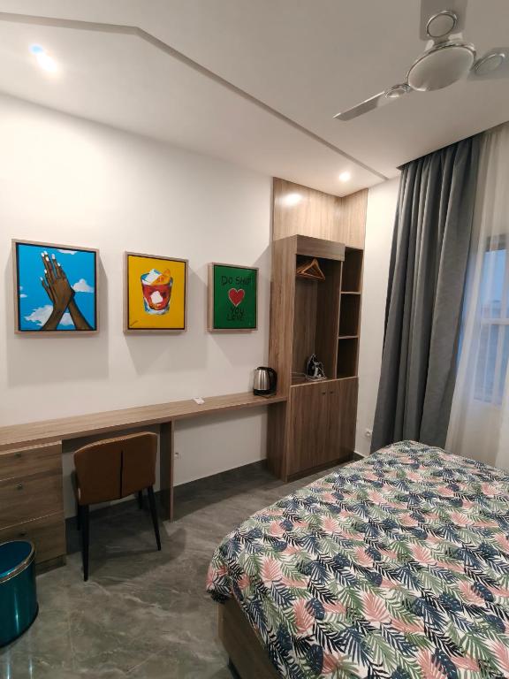 a hotel room with a bed and a desk at La Villa K - 1 Studio in Lomé