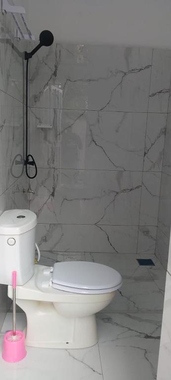 a bathroom with a toilet and a stone wall at cœur d'eden in Vougomé