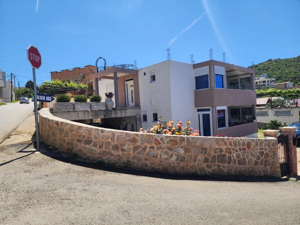 a retaining wall with flowers in front of a house at Lux apartment in Dobra Voda