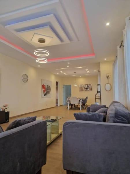 a living room with blue couches and a table at Appartement Güstrow "free energy from solar Panels" in Lomé