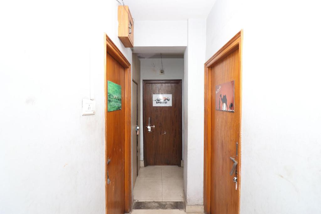 a hallway with two wooden doors in a building at Hotel O Sher E Bengal in Durgāpur