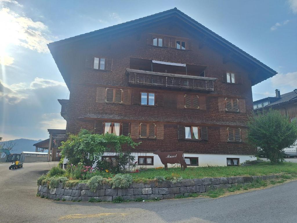 a large brick building with a cow in front of it at Ferienhof Muxel in Großdorf