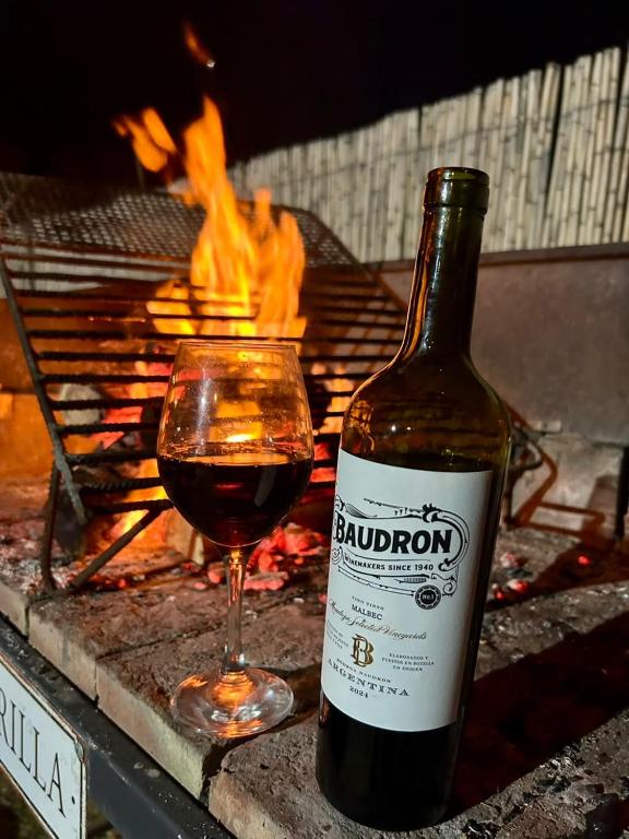 a bottle of wine next to a glass of red wine at La Felita, Tu refugio perfecto en Mendoza in Chacras de Coria
