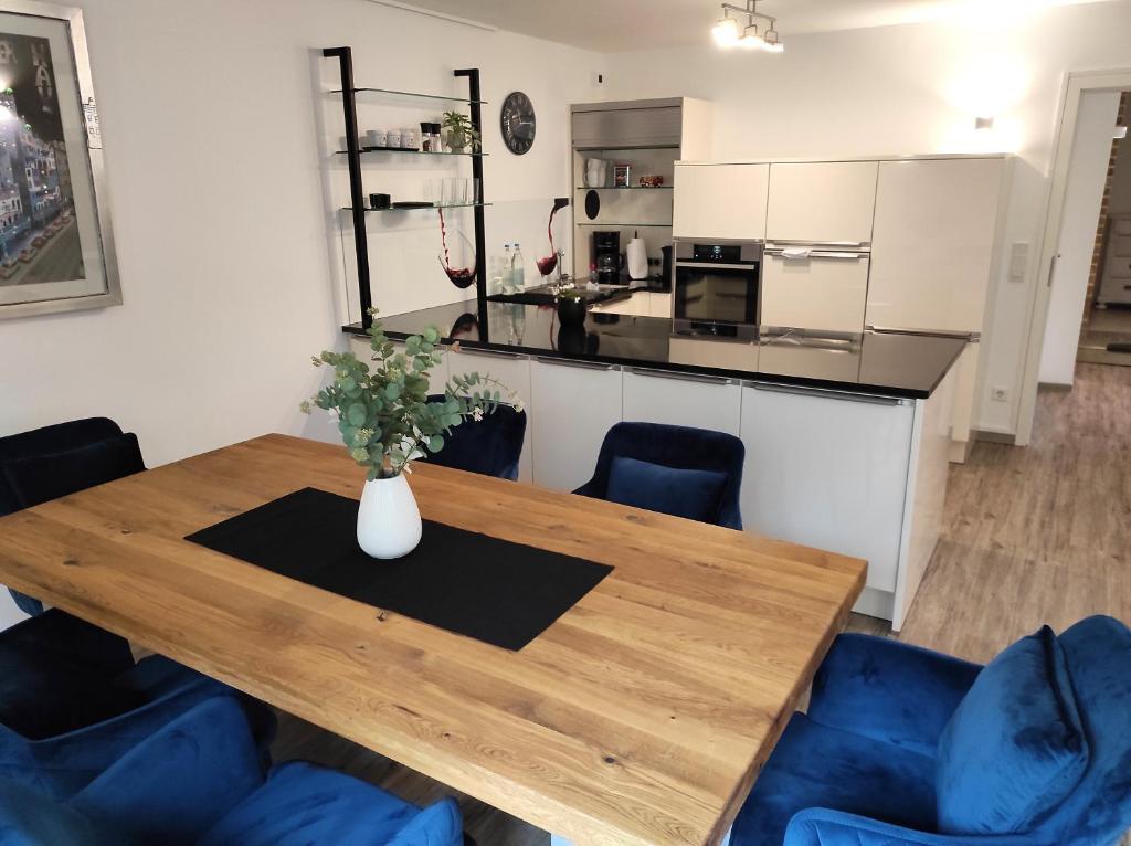 a kitchen with a wooden table and blue chairs at Casa Wohnen und Wellness in Hemer