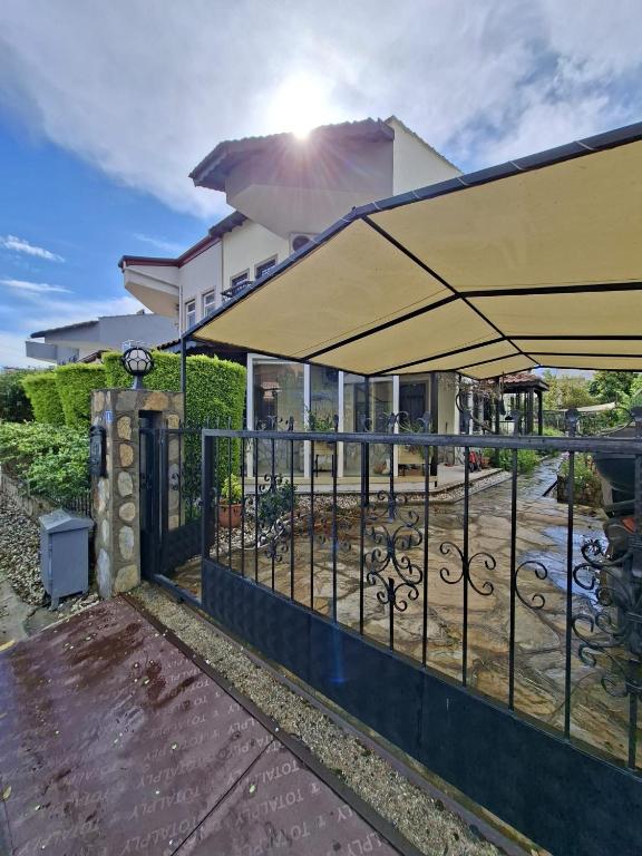 a patio with an umbrella and a fence at Miji Stay in Fethiye
