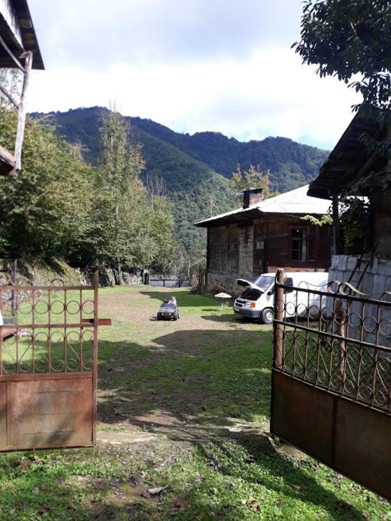 a gate to a yard with a house and a car at wila ZUNDAGA ზუნდაგა 1800 in Zundaga