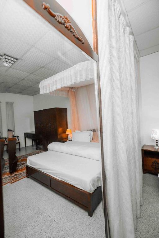 a bedroom with a canopy bed and a desk at Mbeya Forest Hill Motel in Mbeya