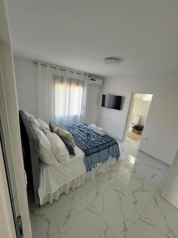 a white bedroom with a bed and a mirror at Luka Vacation House in Ulcinj