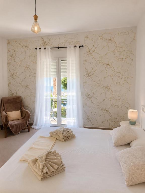 a large white bed in a room with a window at Aggelina's Apartment in Zakynthos