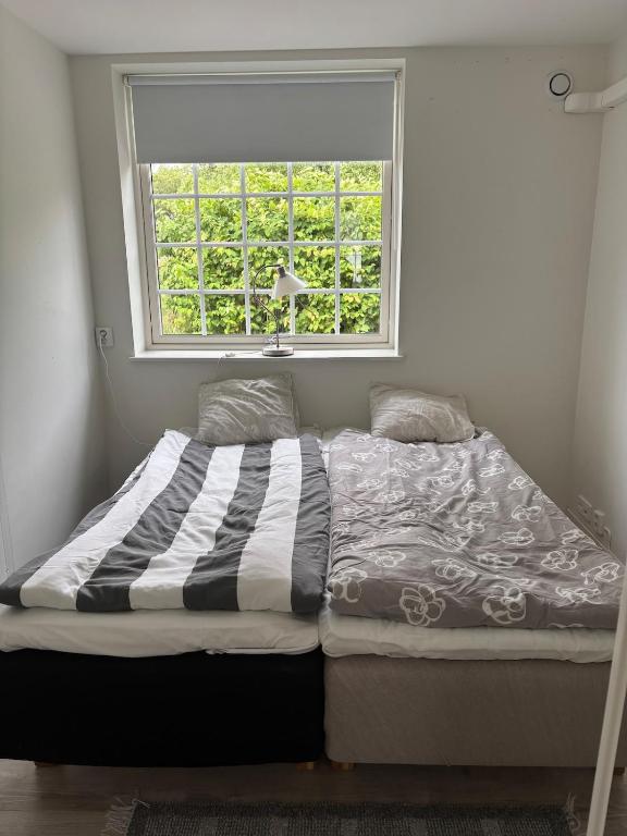 a bed in a room with a window at Bageriet, 1 room, 2 beds in Varberg