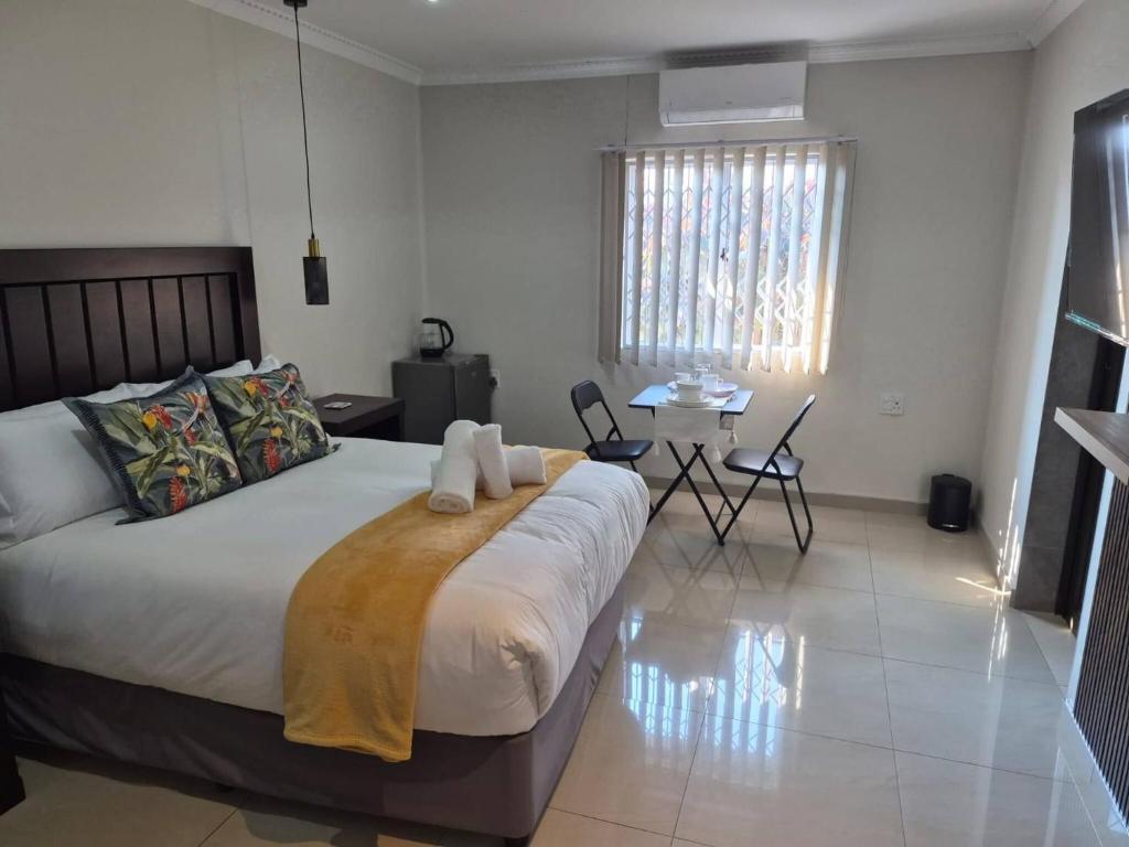 a bedroom with a bed with two towels on it at Nombelas Cottage in Westville