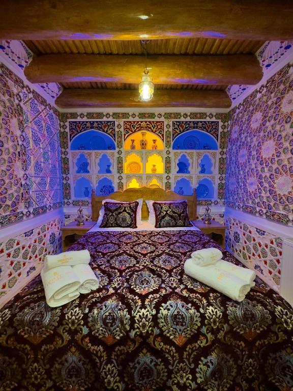 a bedroom with a bed with blue and purple walls at Meriton Hotel Bukhara in Bukhara