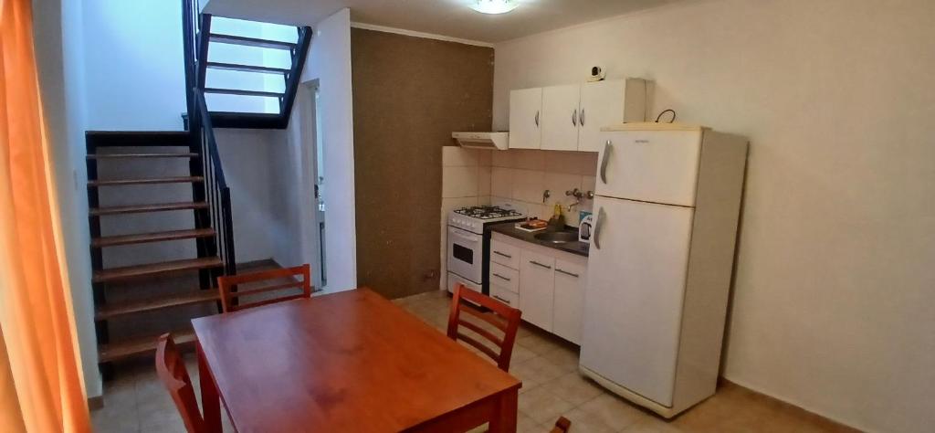 a kitchen with a table and a white refrigerator at Depto Rafaela in Rafaela