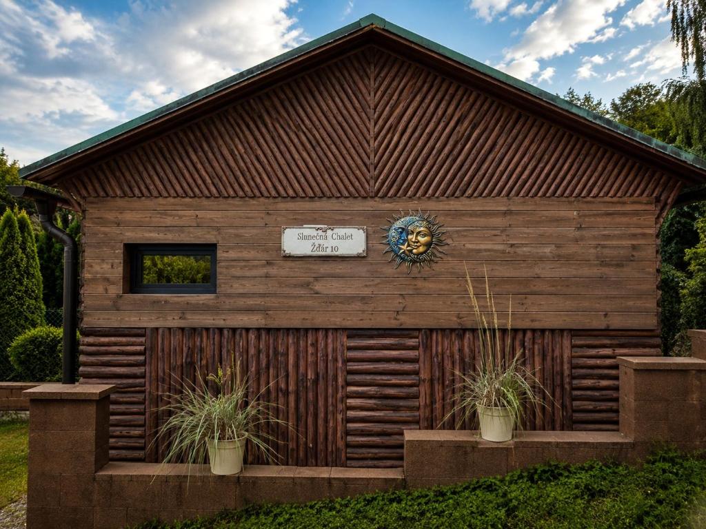 a wooden building with plants in front of it at Slunečná Chalet in Velké Chvojno