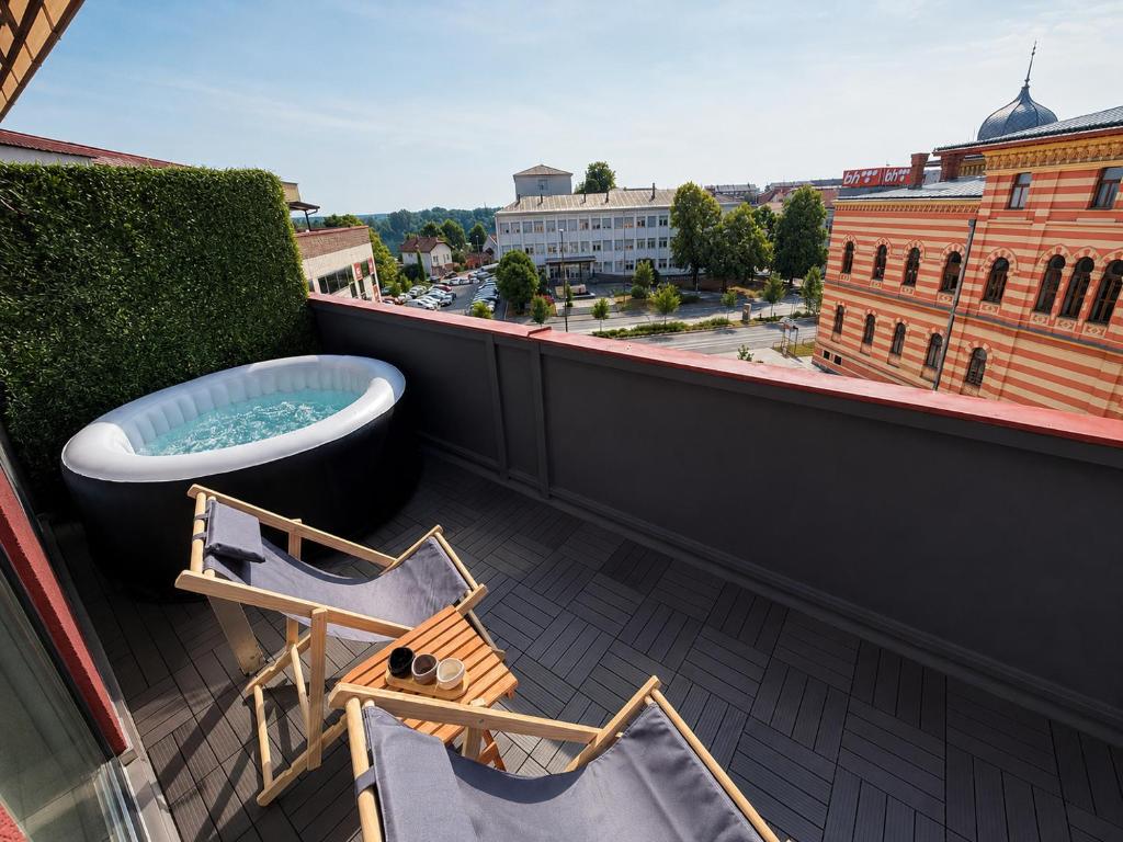 a balcony with chairs and a bath tub on a roof at Cartagena Urban Escape in Brčko