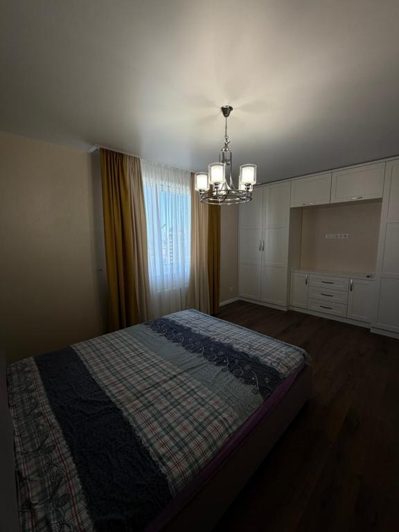 a bedroom with a bed and a chandelier at 56 Жемчужина in Odesa