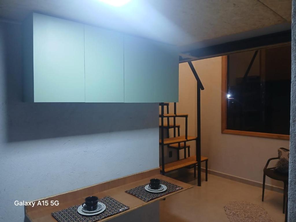 a living room with a table and a blue ceiling at Chalé Recanto Sonho Azul in Extrema