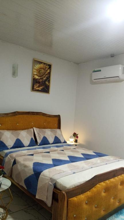 a bedroom with a bed with a blue and white comforter at Résidence IRIS Yamoussoukro in Yamoussoukro