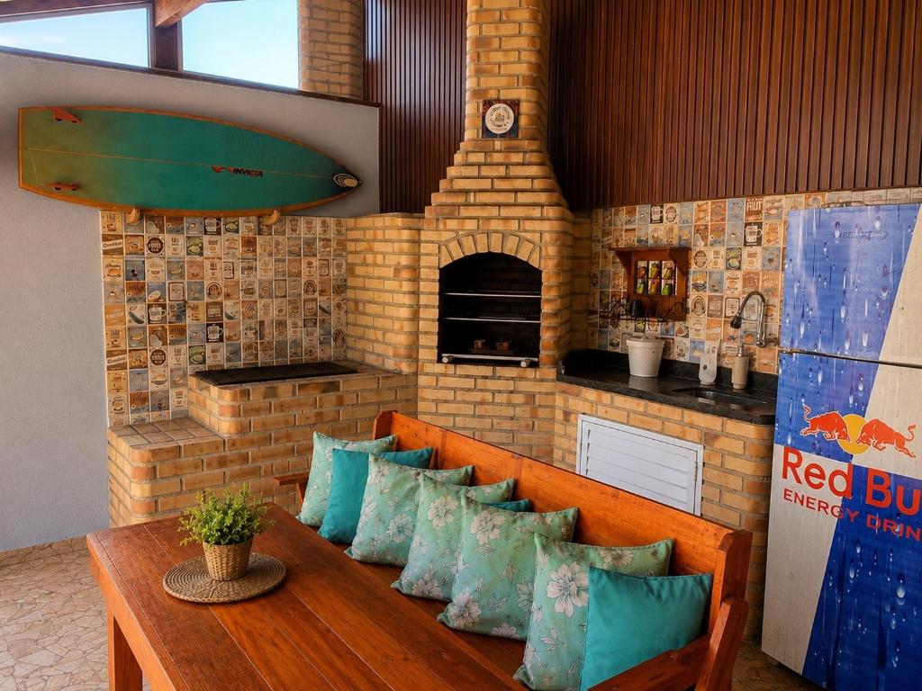 a bench in a room with a surfboard on it at Casa Nova Praia Vivamar in Cabo Frio