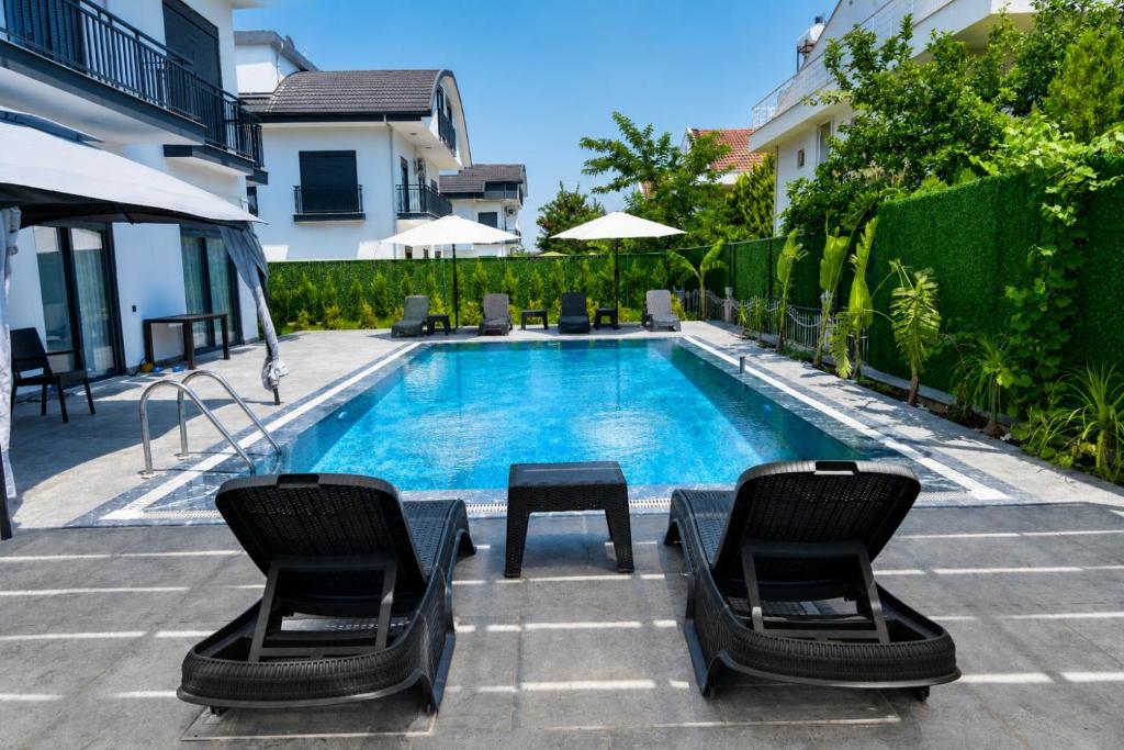 a swimming pool with two chairs and a table at ViLLA ANGEL AHMET HASAN in Belek