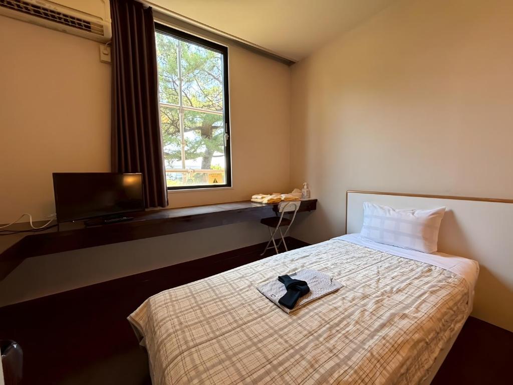 a hotel room with a bed with a tie on it at パークホテル楽々園 in Maebashi