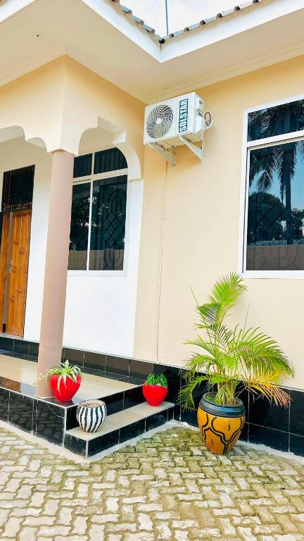 a house with two potted plants in front of it at Uluguru Breeze in Morogoro