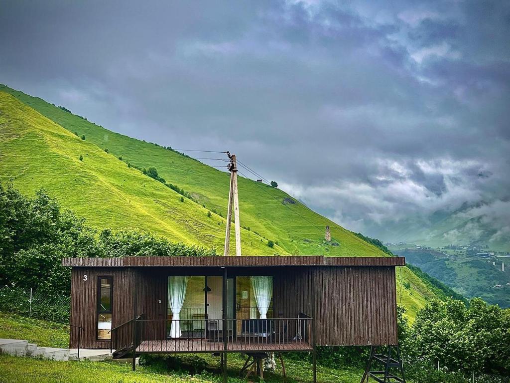 a small house on a hill with a green hill at Container House Zakani in Zak'at'kari