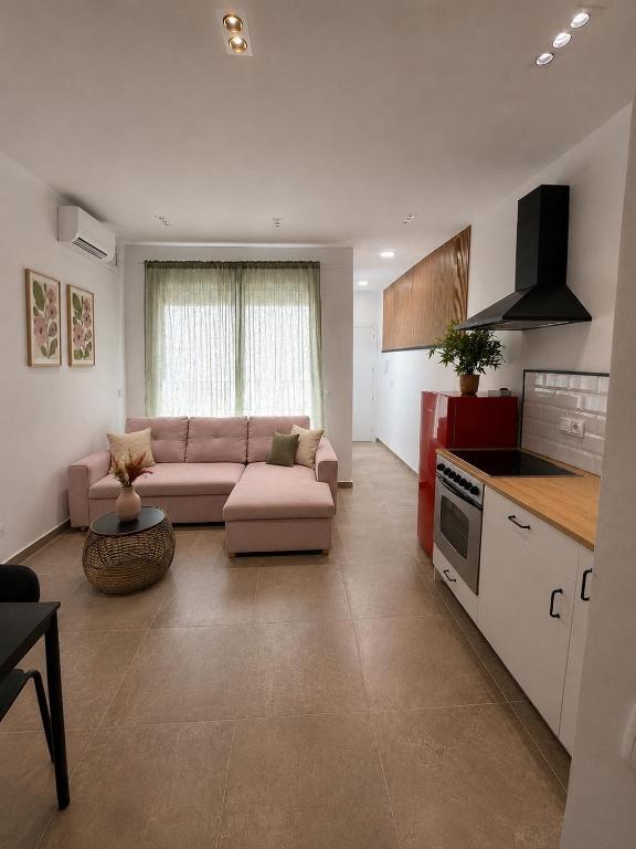 a living room with a couch and a kitchen at Andalucía Suites in Almería