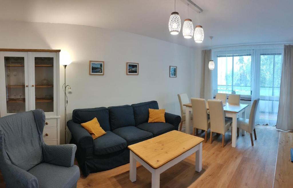a living room with a blue couch and a table at Apartman AK Slatinany in Chrudim