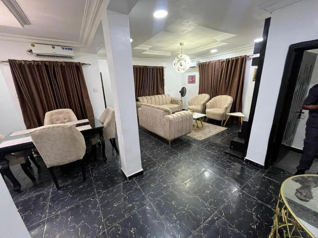 a living room with a table and chairs and a room with a table at ParamountLuxe 4 bedroom duplex in Ikeja in Ikeja