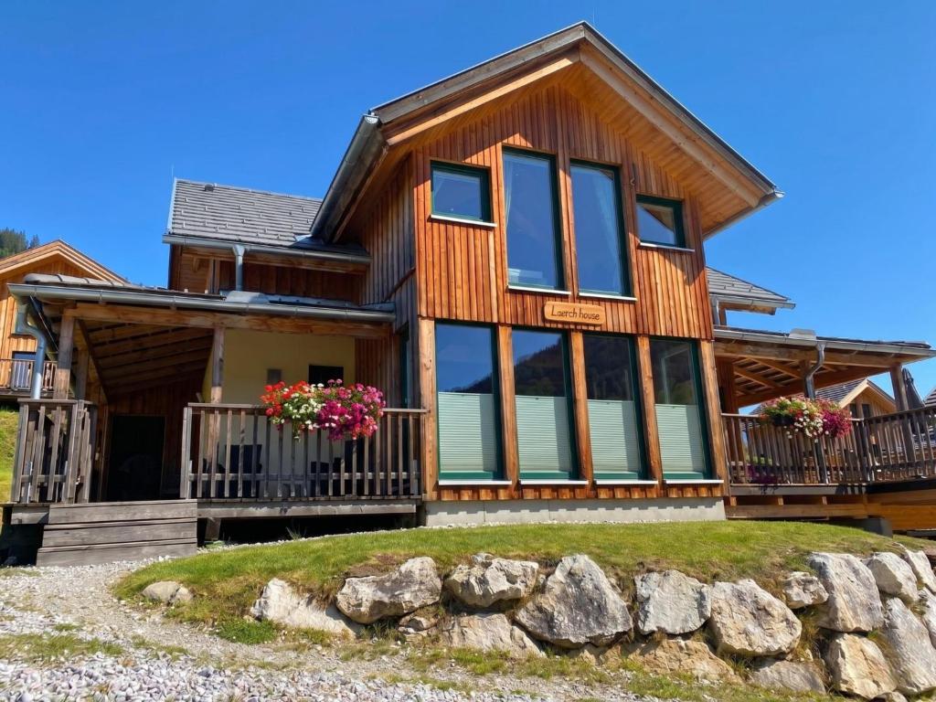 a log home with large windows and rocks at The Laerch in Hohentauern