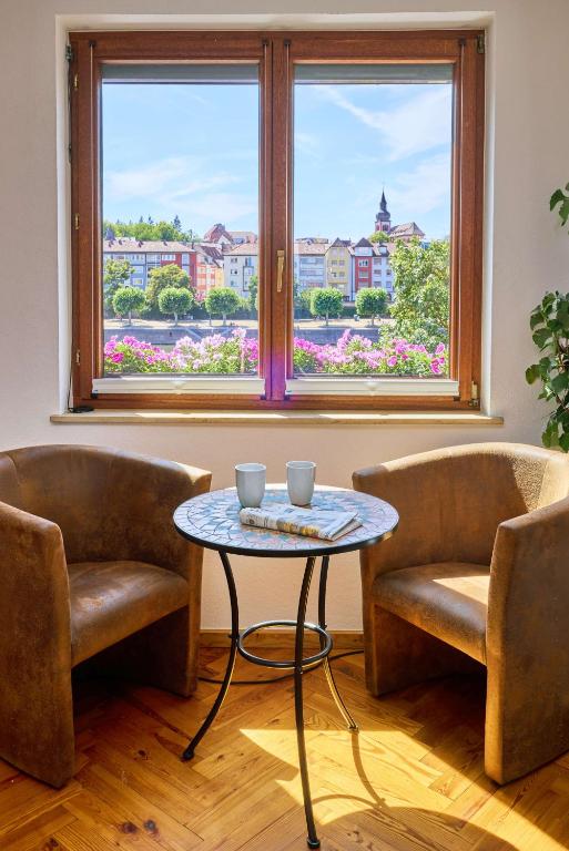 a room with two chairs and a table and a window at FeWo Alte Mainbrücke in Würzburg